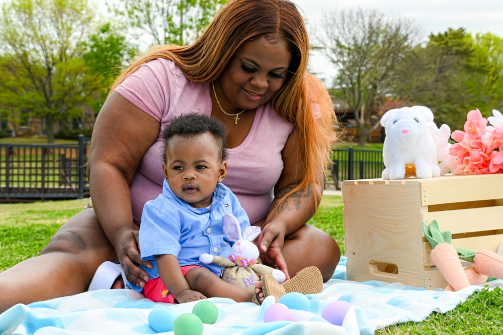 woman in pink tank top carrying baby in blue and white tank top