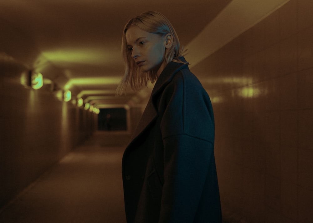 woman in black coat standing on hallway