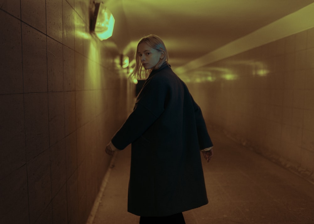 woman in black coat standing on hallway