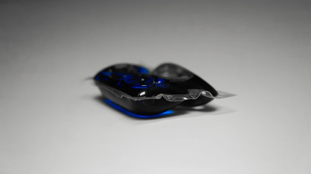 A pod dissolving in water inside a washing machine drum.