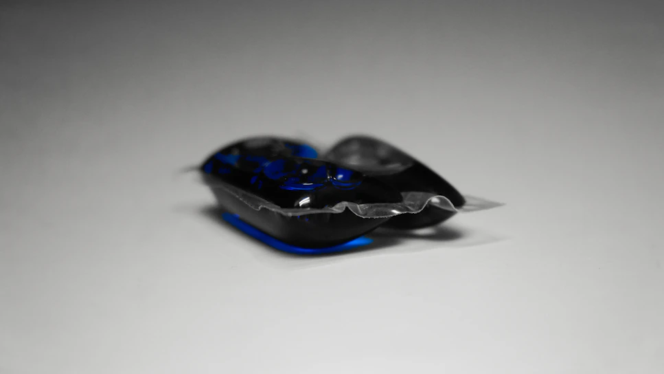 Close-up of eco-friendly True Tides powder detergent scooped in a wooden spoon over a rustic linen cloth.