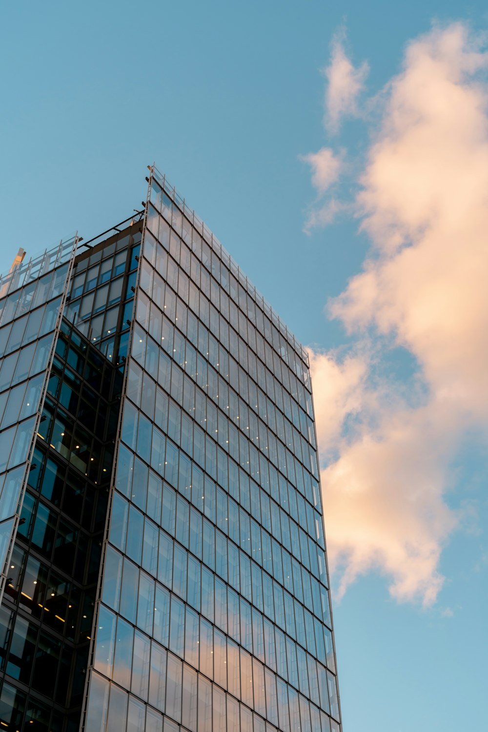 Edificio amurallado de vidrio azul y blanco bajo el cielo azul durante el día