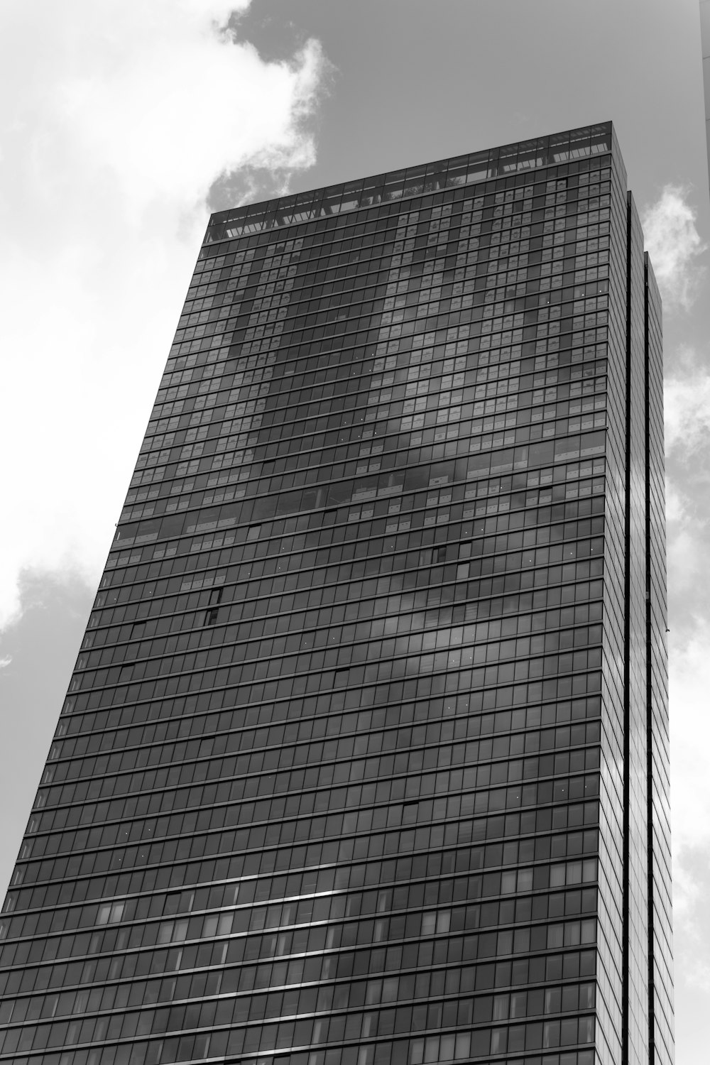 black high rise building under white clouds during daytime