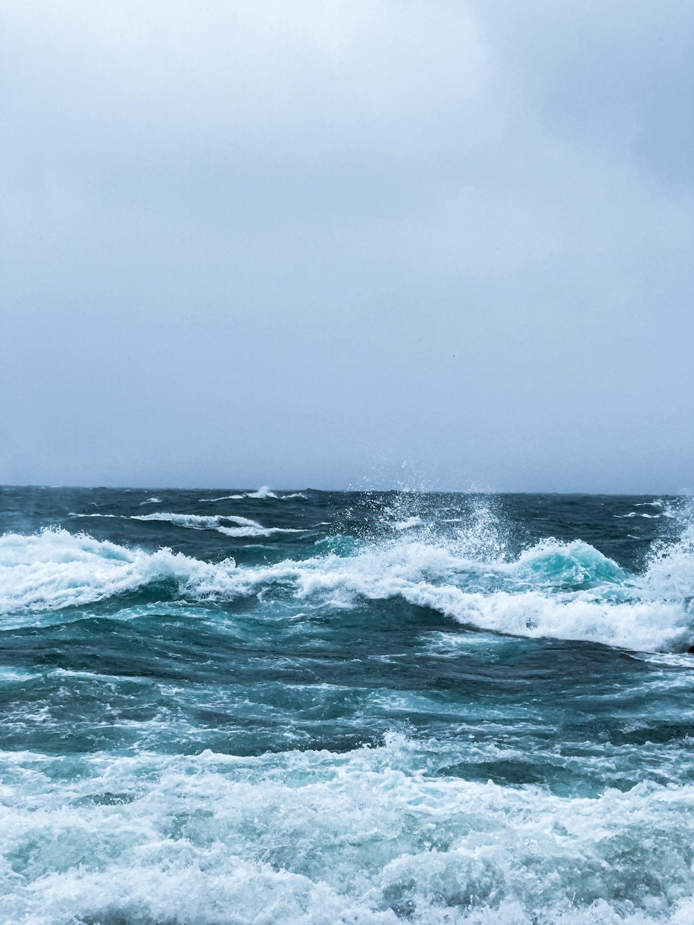 Mar embravecido con olas rompiendo bajo un cielo gris de tormenta