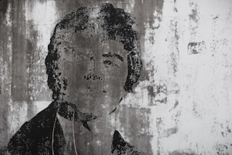 A candid portrait painted on a textured wall, reflecting individuality and authenticity.