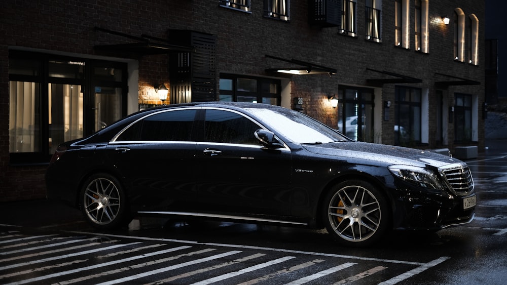 black sedan parked on sidewalk during daytime