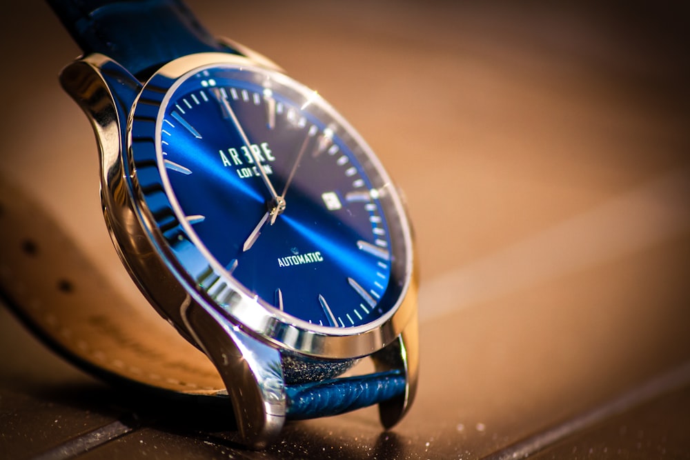 blue and silver round analog watch