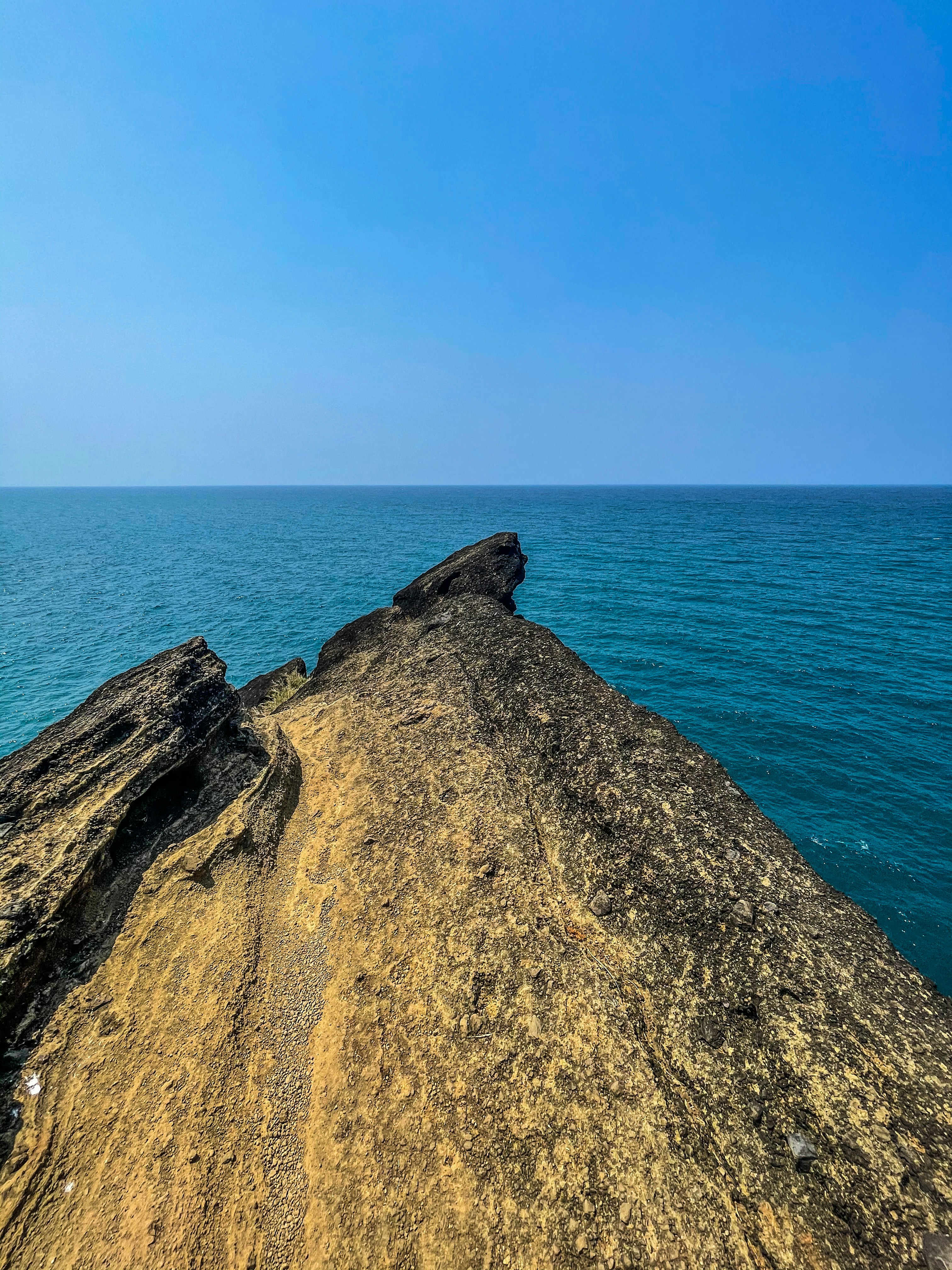 brown rock formation near blue sea during daytime