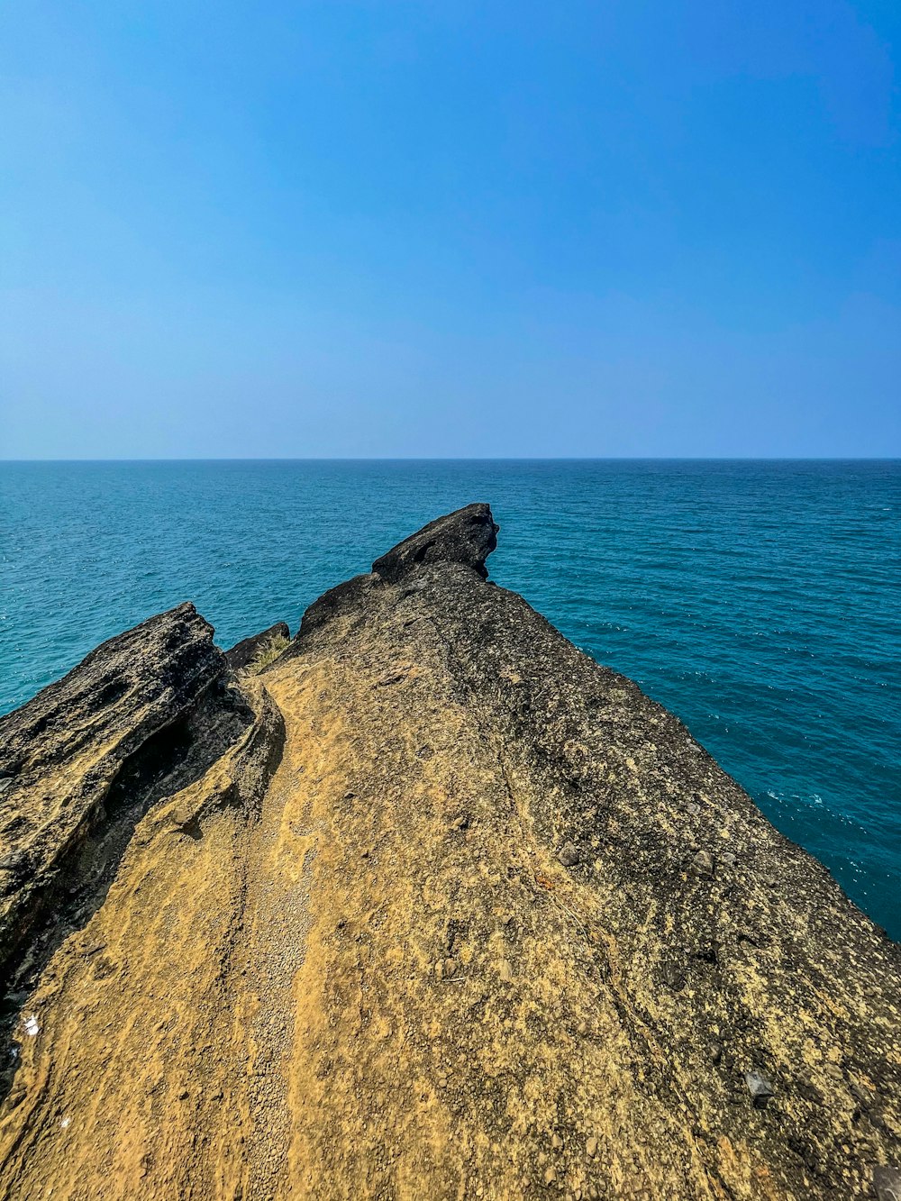 brown rock formation near blue sea during daytime