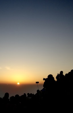 Sunrise view over the horizon, with team members preparing instruments in silhouette.