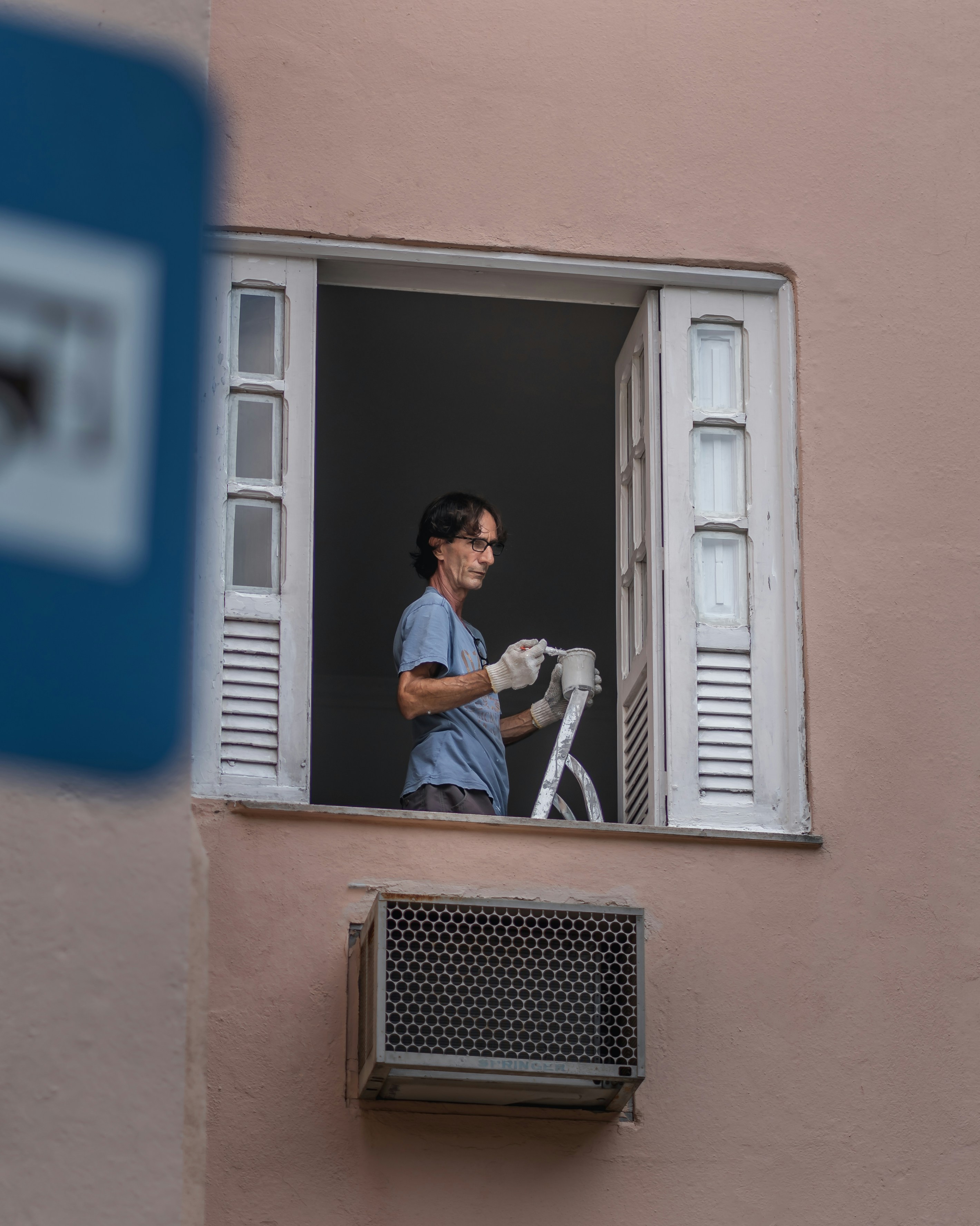 man in black and white striped long sleeve shirt sitting on window during daytime