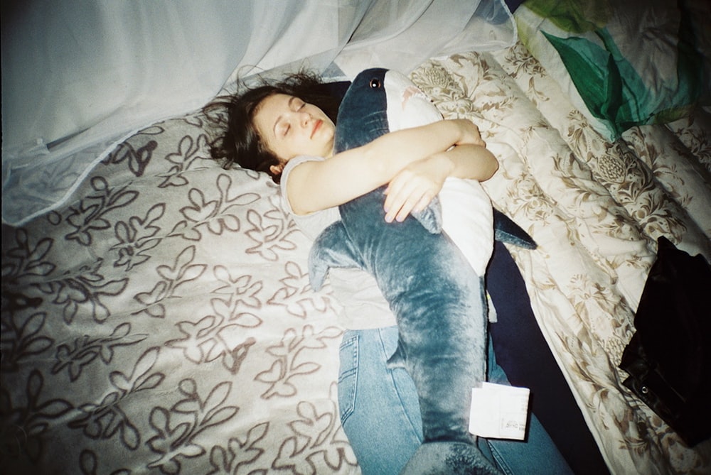 woman in blue denim jeans lying on bed