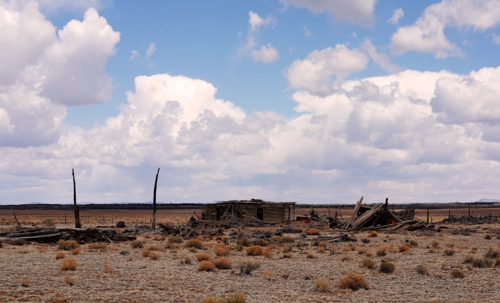 brown wooden fence on brown field under blue and white cloudy sky during daytime