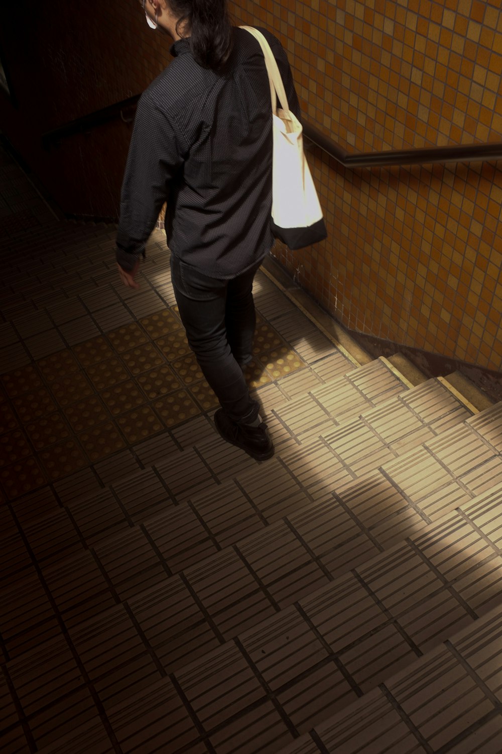 person in black pants standing on brown brick floor