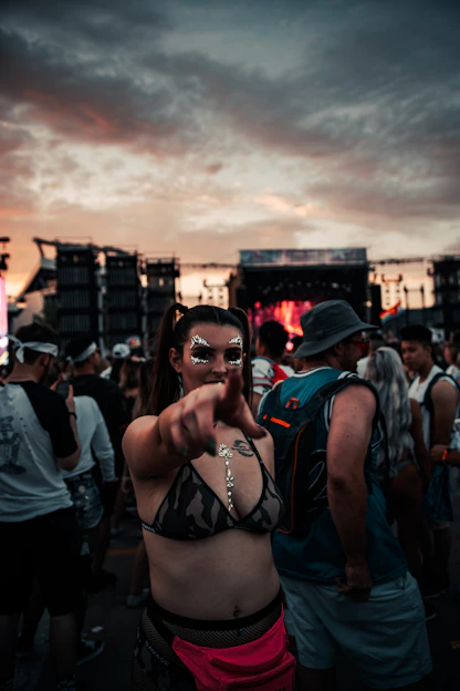 Photo of David Stringer at a local music festival, holding a camera with a backdrop of a lively crowd at sunset.