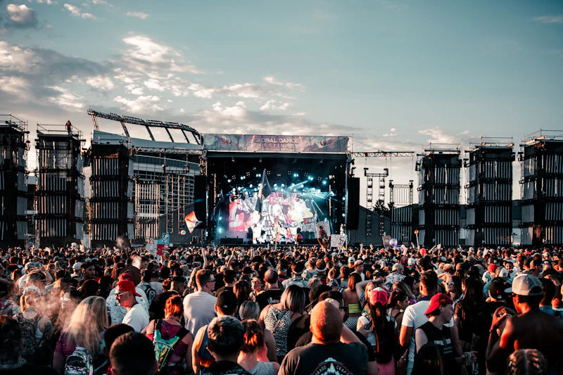 A crowd at an outdoor festival stage in the afternoon