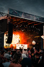 Vibrant outdoor music festival scene with Uncle Artie&amp;amp;amp;amp;#x27;s catering tent serving wings to a lively crowd.