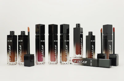 A set of three lipcream tubes in pastel shades arranged elegantly on a wooden table.