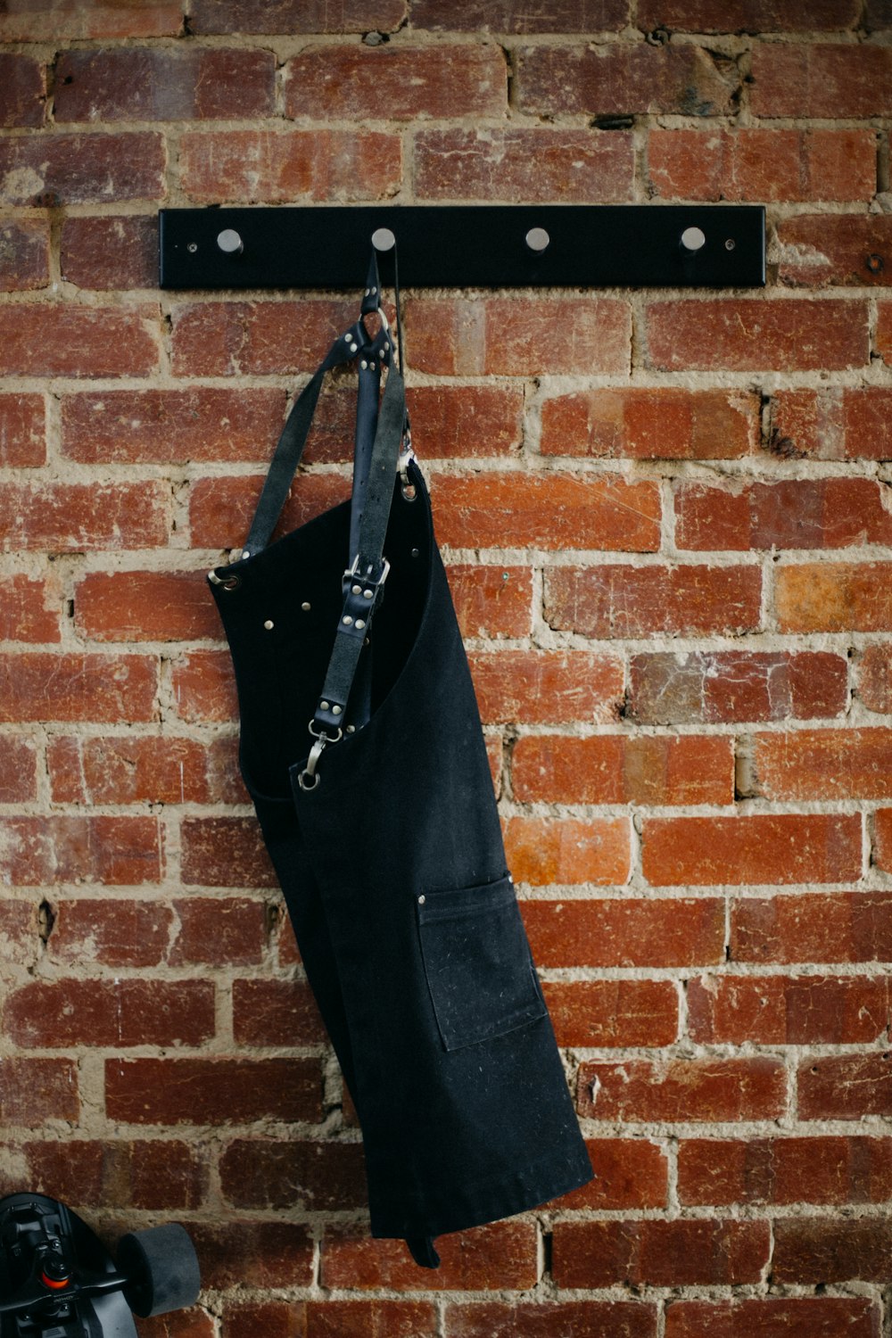 black sling bag on brown brick wall