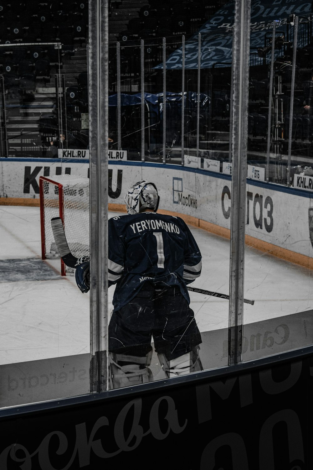 man in black and white ice hockey jersey standing on ice field