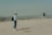 man and woman standing on sand during daytime