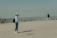 man and woman standing on sand during daytime
