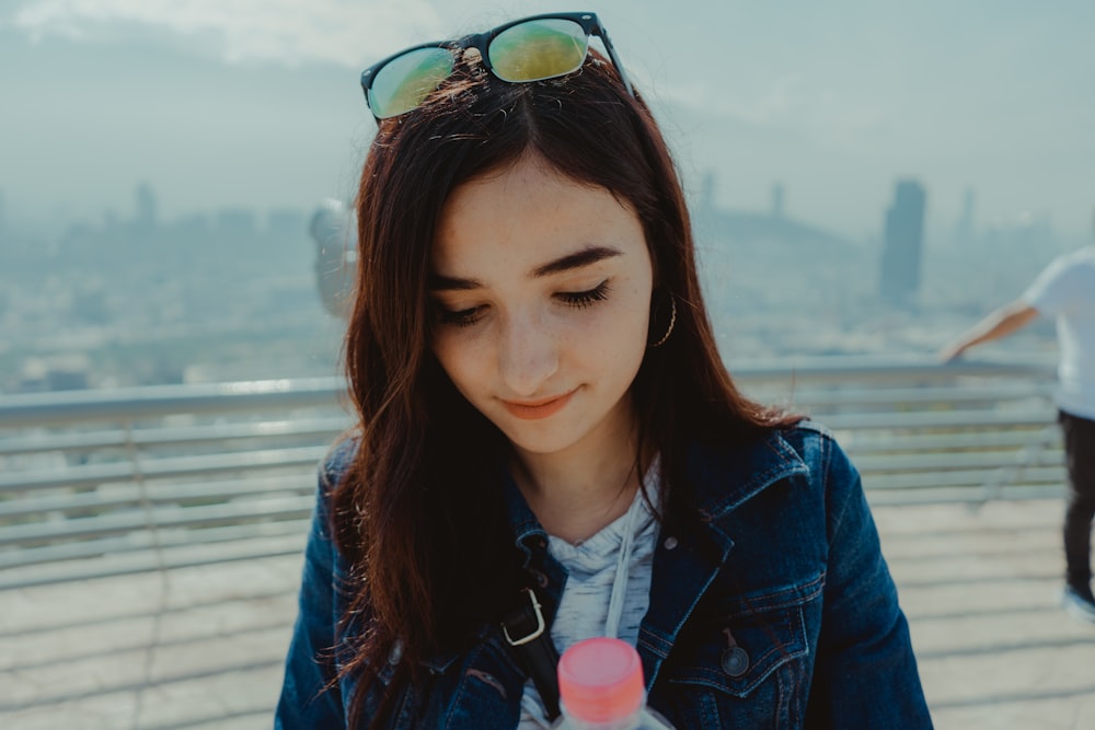 woman in blue jacket wearing black sunglasses