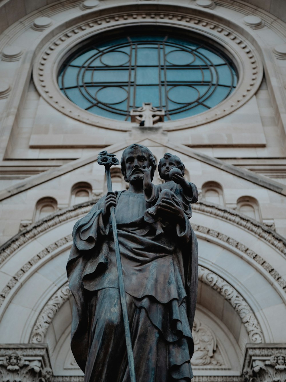 black statue of man holding book