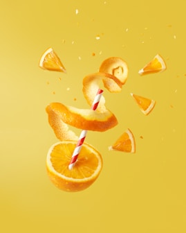 sliced orange fruit on yellow surface