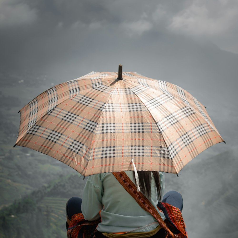 person in blue denim jeans holding umbrella