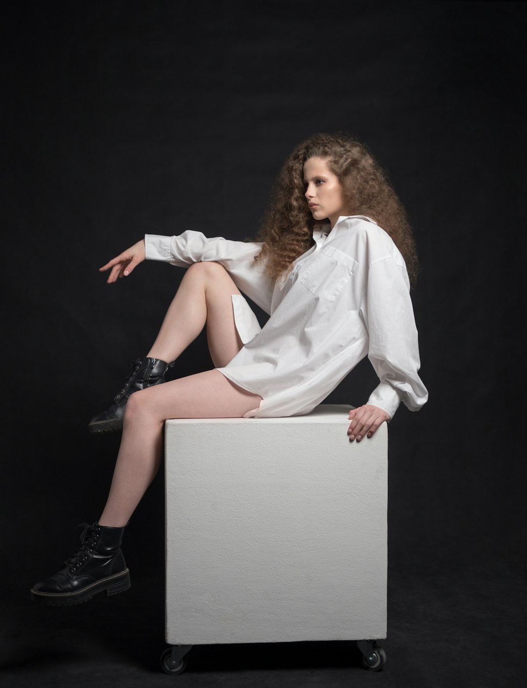 woman in white long sleeve shirt and black skirt sitting on white wooden table