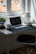 A modern desk with a minimalist checklist printout, a sleek pen, and natural light streaming in.