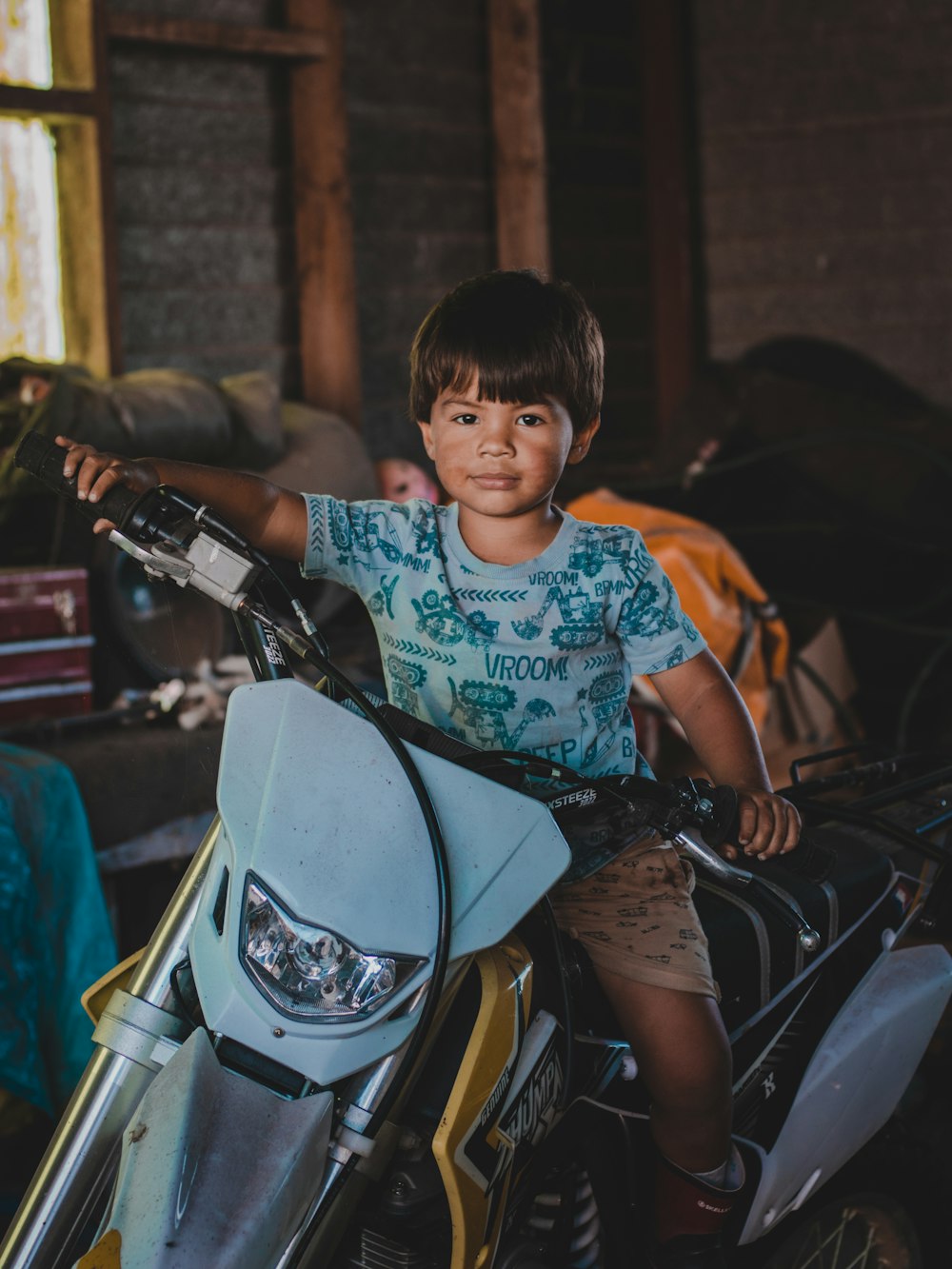 boy in blue and white floral shirt riding on motorcycle