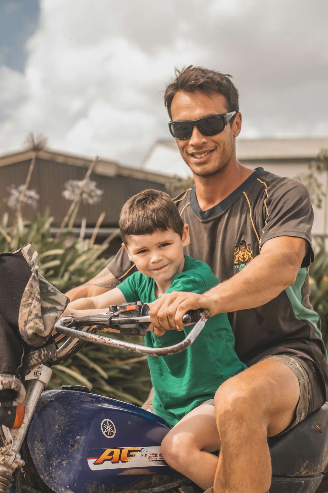 boy in grey crew neck t-shirt and black shorts sitting on black and grey bicycle