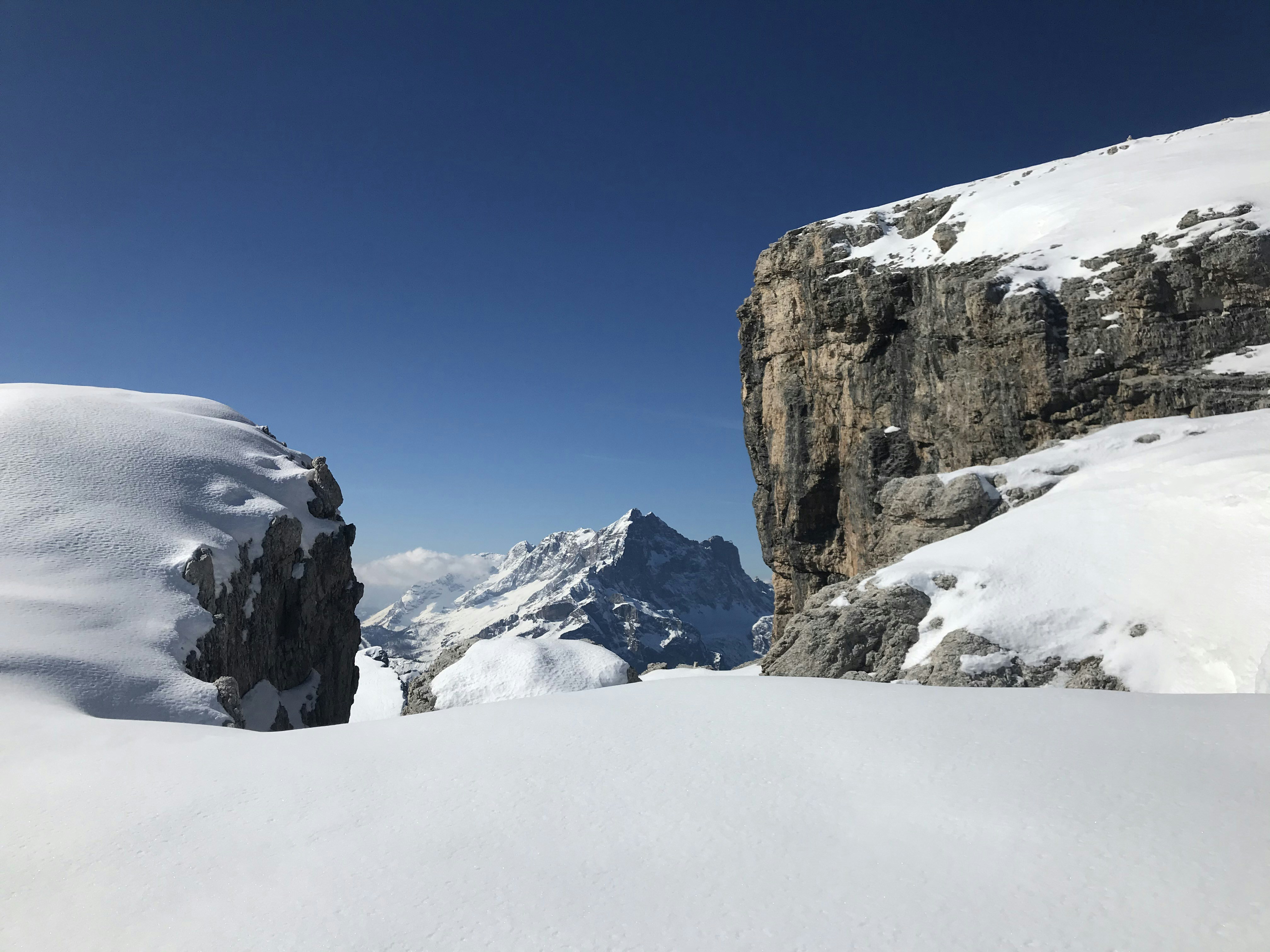 brown rocky mountain covered by snow under blue sky during daytime