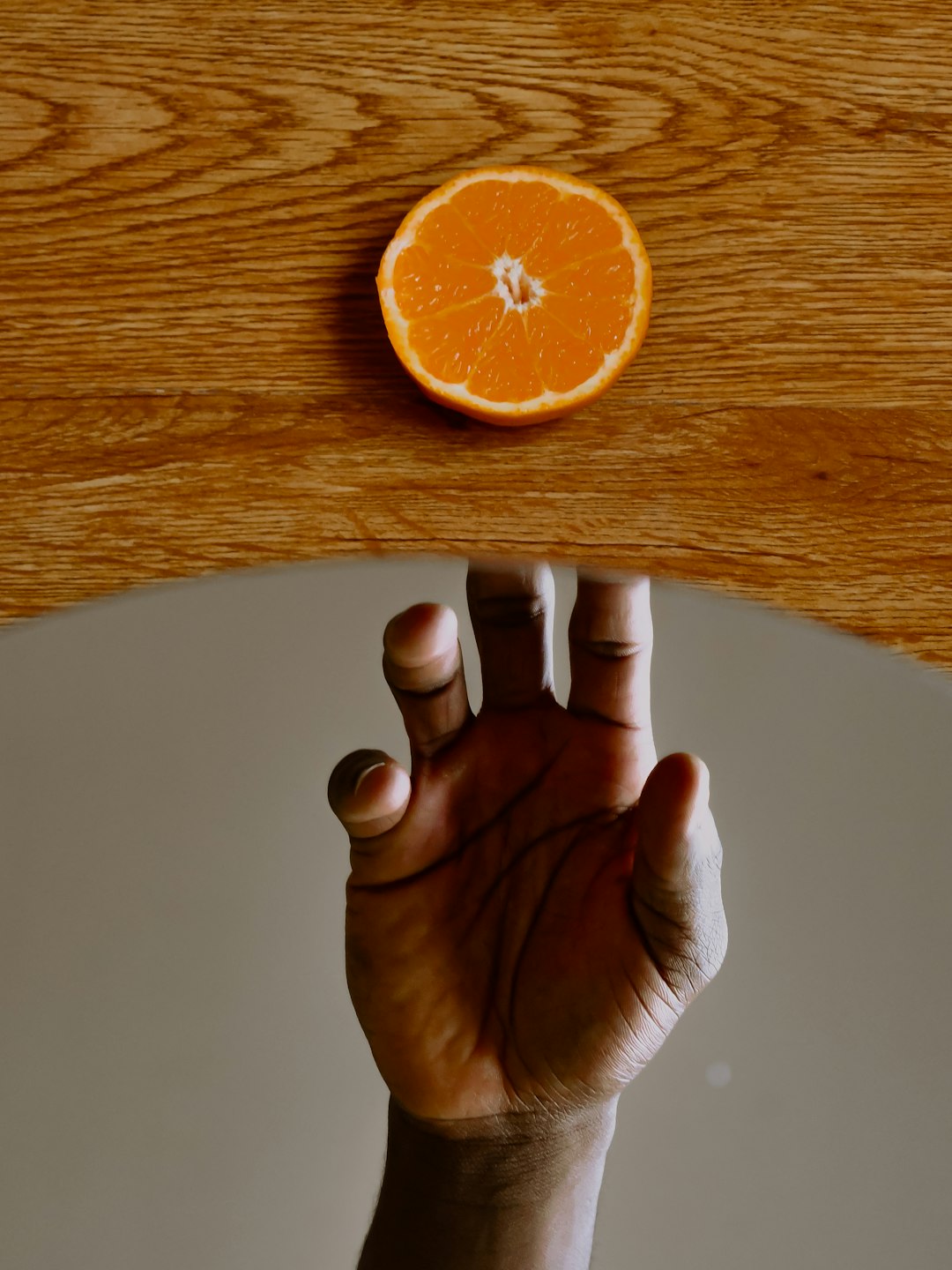 person holding orange fruit on white table