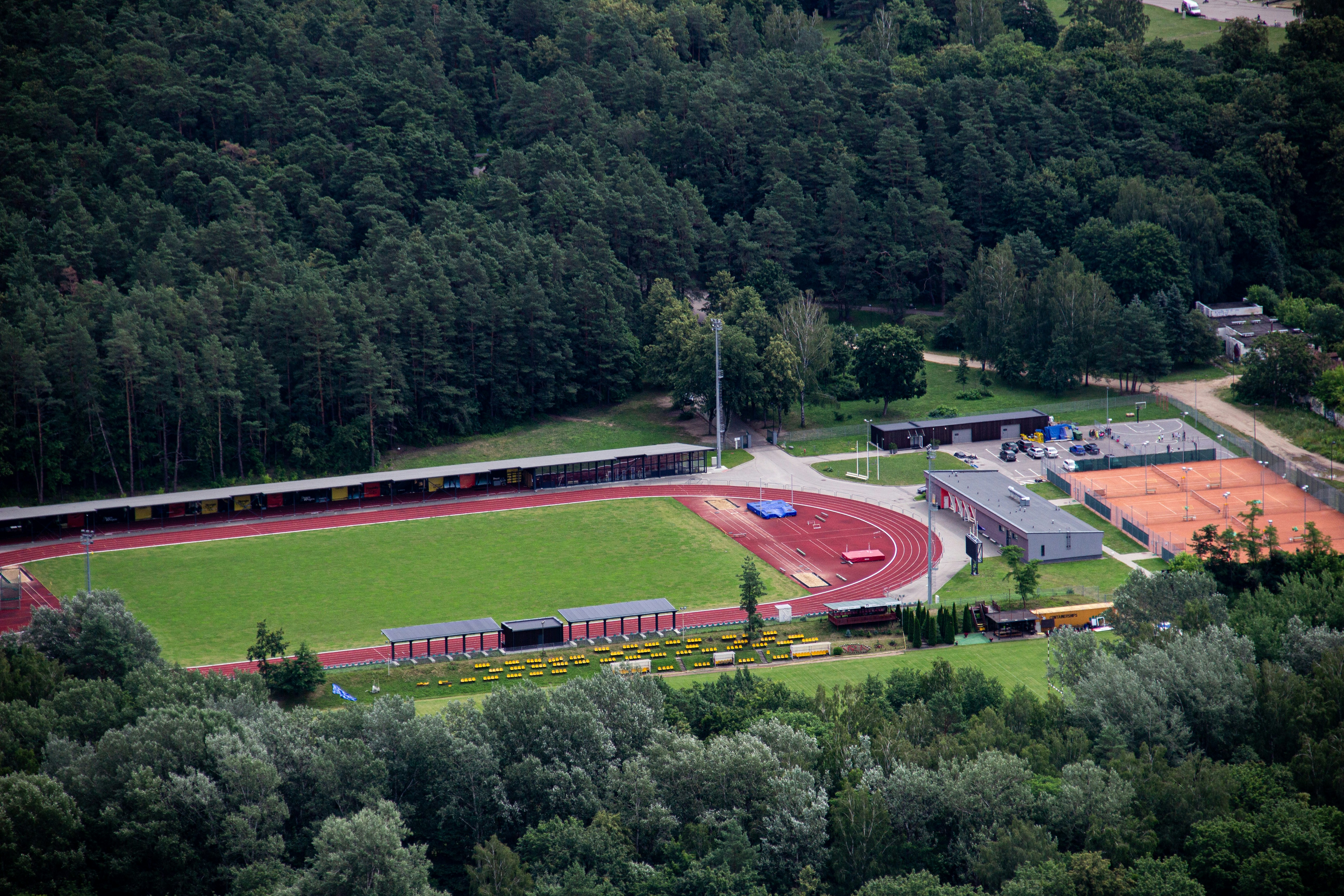 red and white stadium surrounded by green trees during daytime
