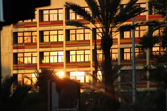 A contemporary commercial building with glass facades reflecting the vibrant Goan coastline at sunset.