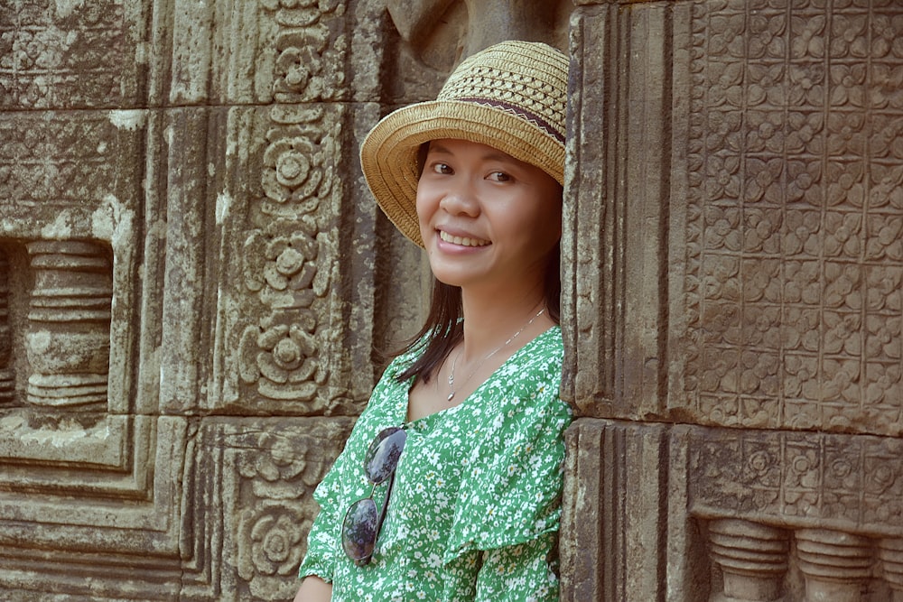 woman in green and white floral dress wearing brown hat