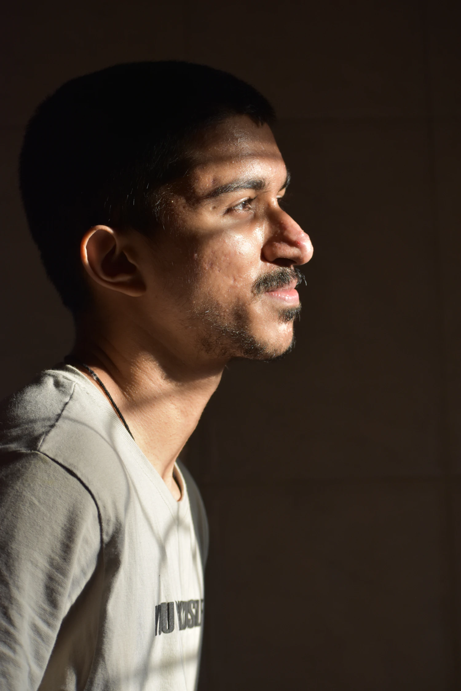 Nikhil Soneji in profile against a warm studio wall