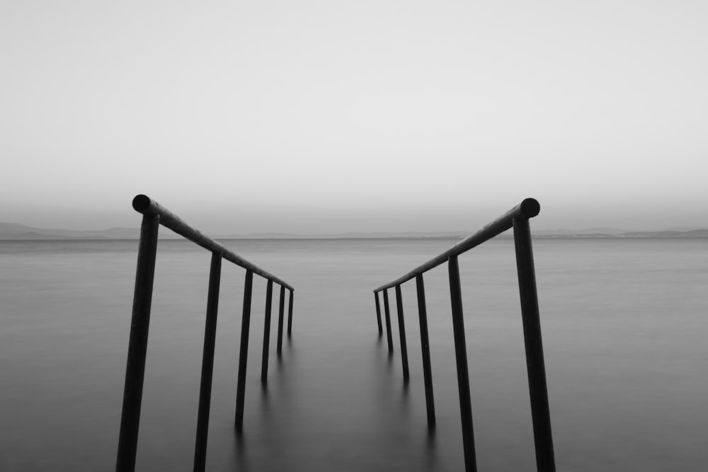 grayscale photo of wooden dock on sea