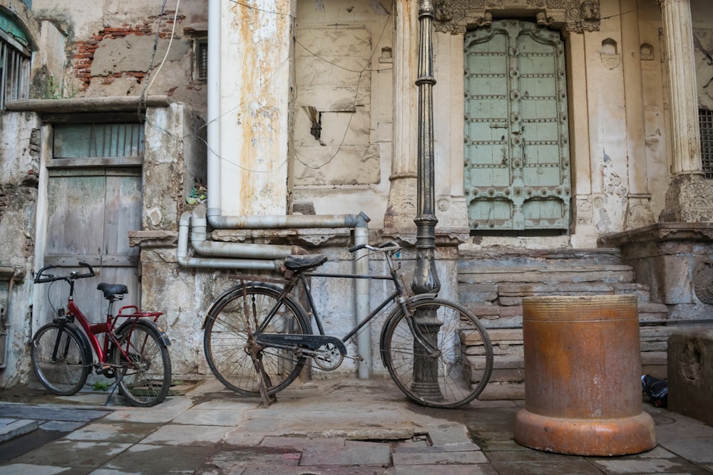 Bici da città nera parcheggiata accanto all'edificio in cemento bianco durante il giorno