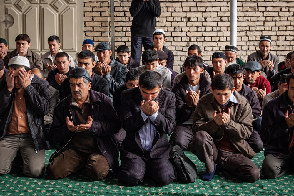 group of men sitting on green floor