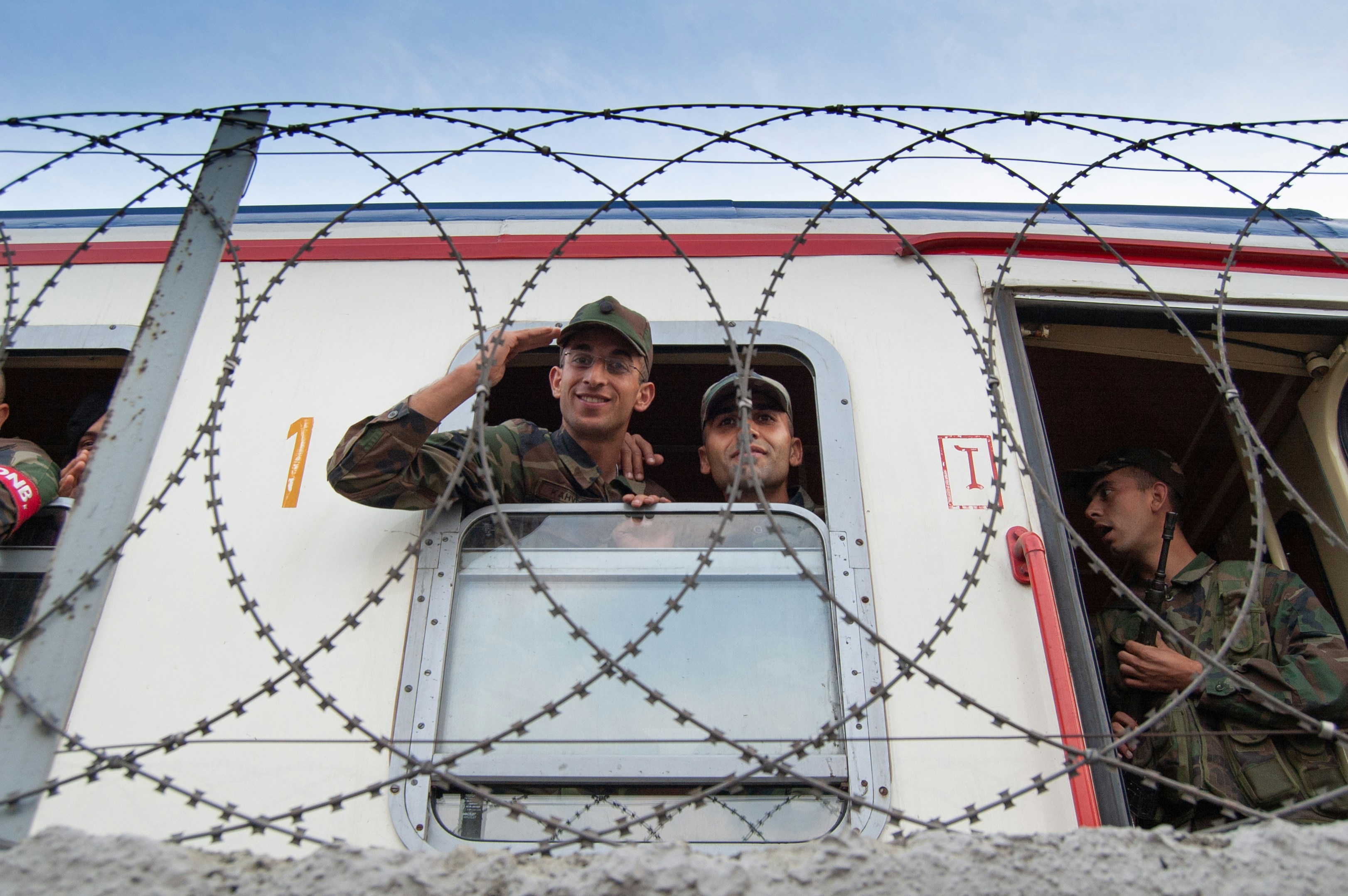 woman in black jacket sitting on white and red car during daytime