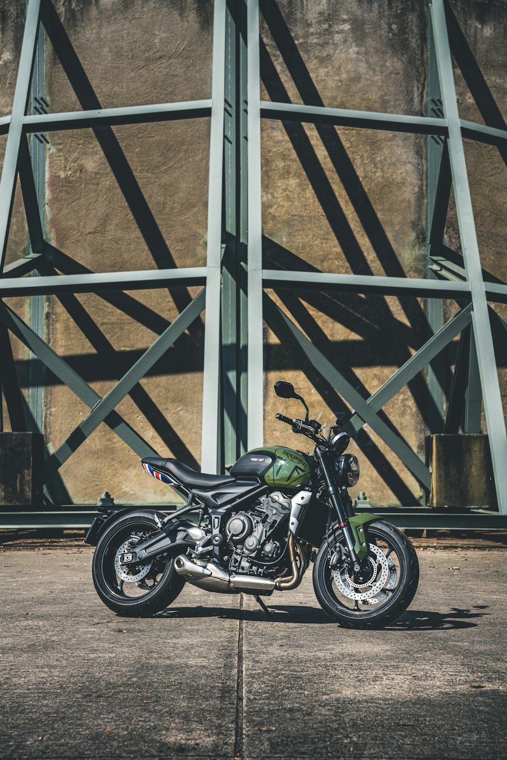 black and green sports bike parked beside gray metal frame