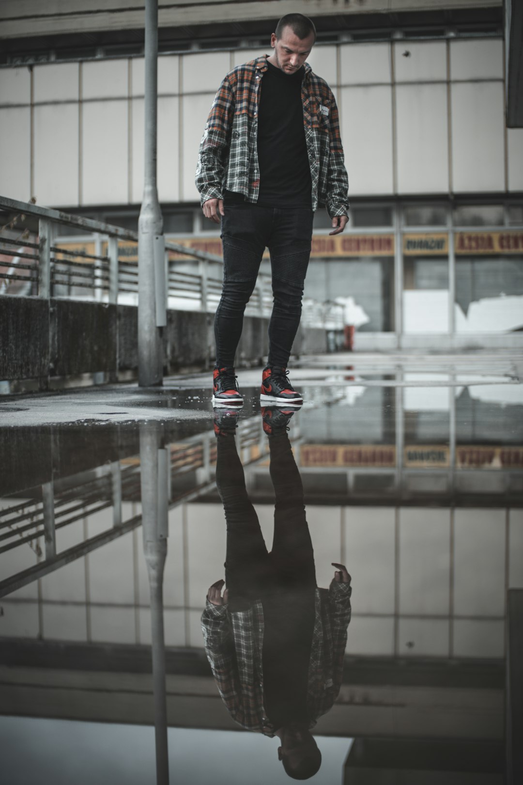 person in black pants and black boots standing on escalator