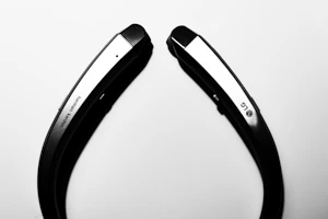 A stylish neckband headset displayed with a clean, dark backdrop highlighting its design