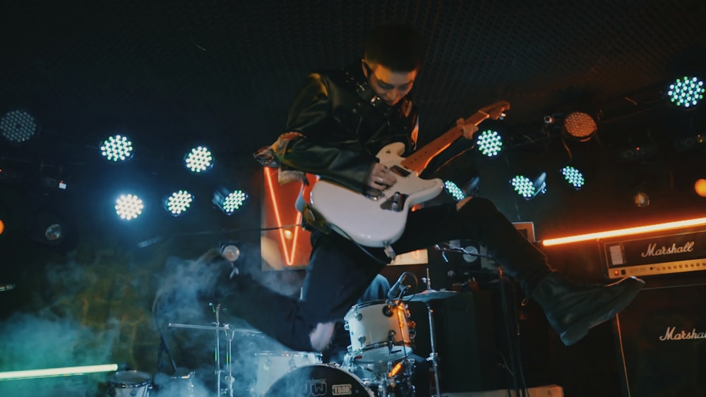 man playing guitar on stage