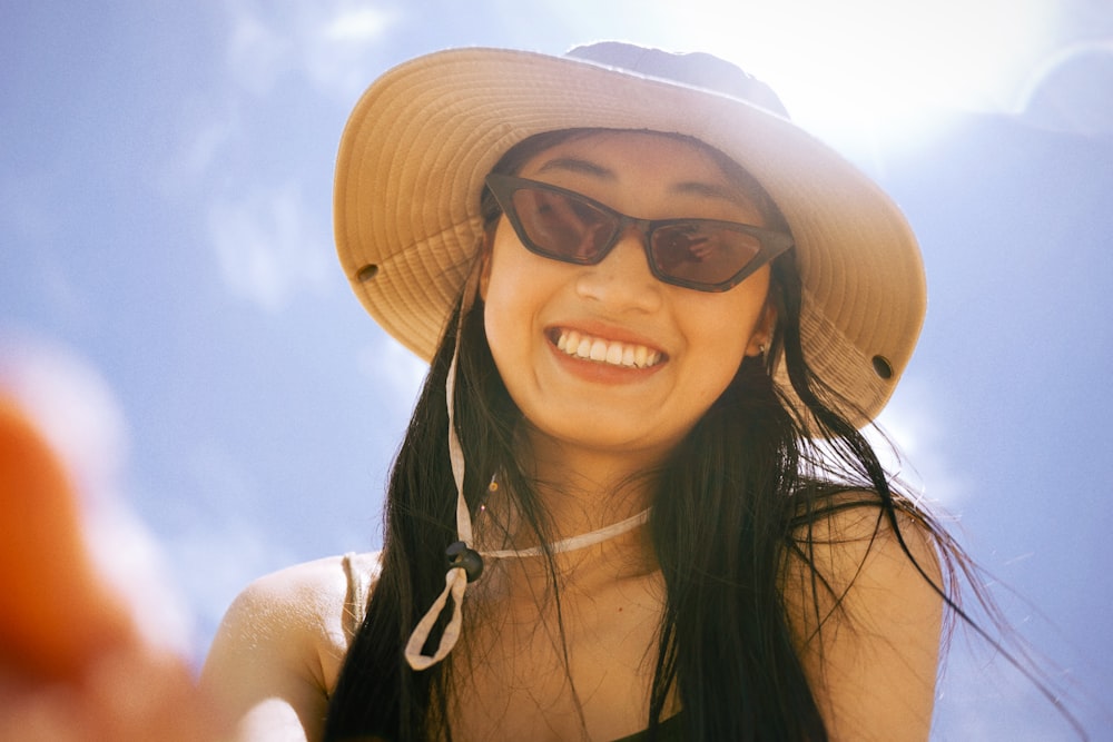 woman in black tank top wearing brown sun hat and black sunglasses