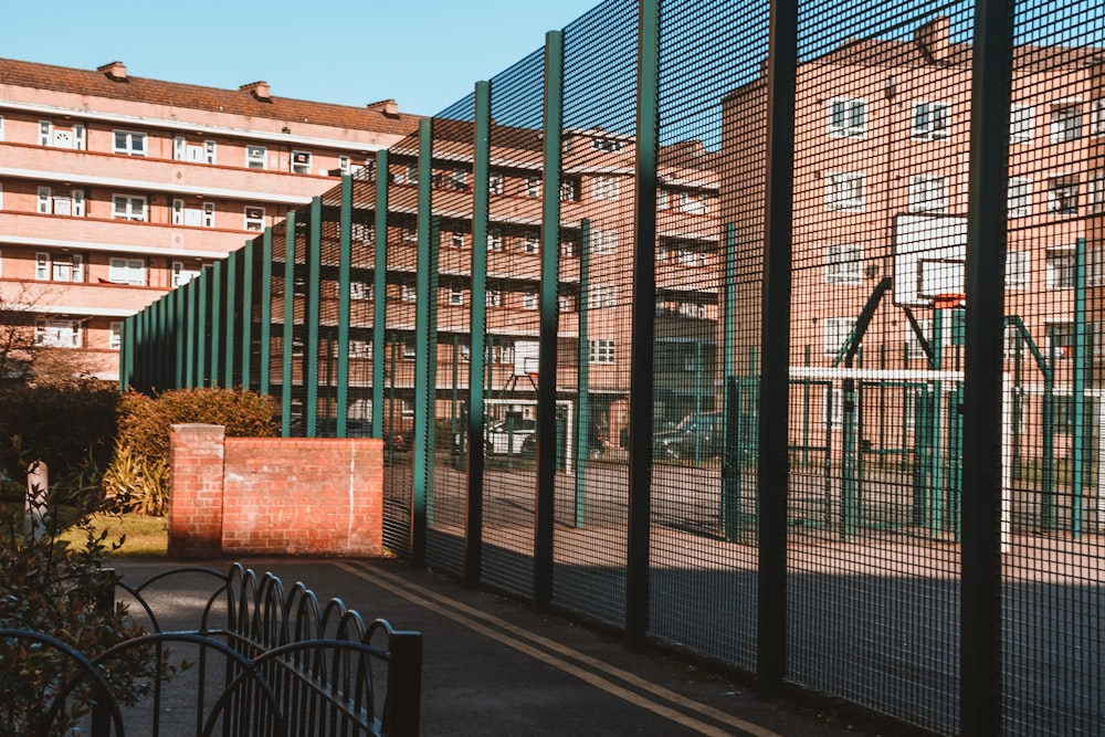 black metal fence near brown brick wall building during daytime